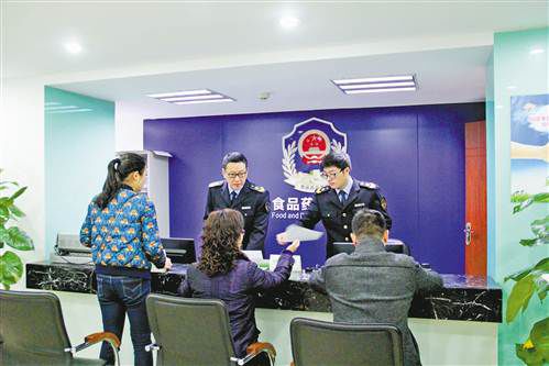 江北区观音桥街道食品药品监管所工作人员指导市民填写申报资料。